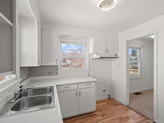 kitchen featuring visible vents, a sink, a wealth of natural light, and white cabinetry