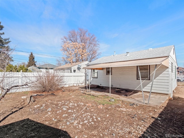 rear view of property featuring fence