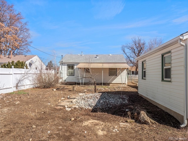 rear view of house featuring fence