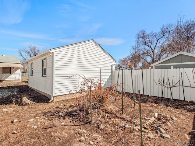 view of side of home featuring fence