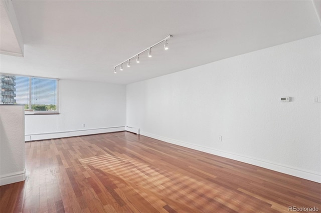 740 N Pearl St Unit 606, Denver, CO 80203 - spare room featuring a baseboard radiator, wood finished floors, and rail lighting