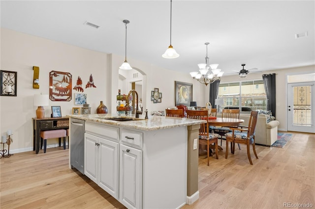 kitchen with sink, white cabinetry, dishwasher, pendant lighting, and a kitchen island with sink