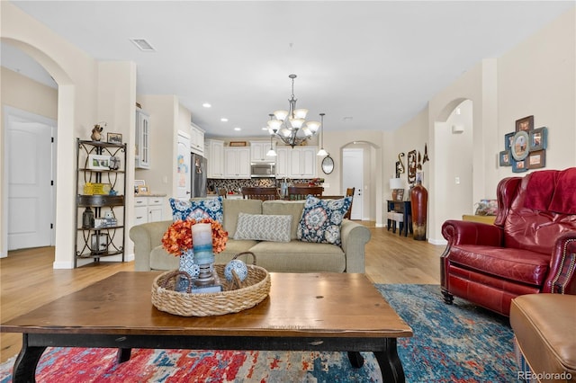 living room featuring a notable chandelier and light hardwood / wood-style floors