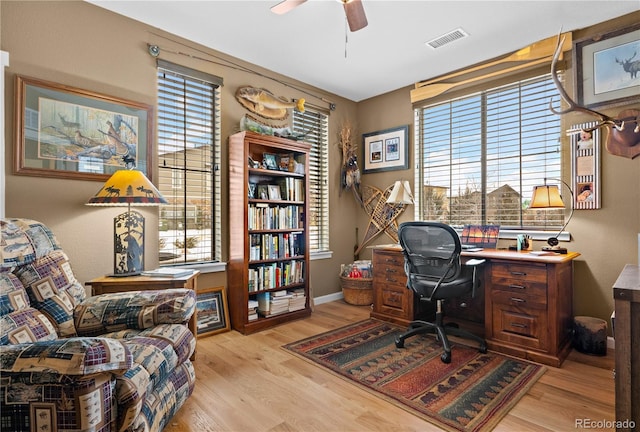 home office with ceiling fan, light hardwood / wood-style floors, and a healthy amount of sunlight