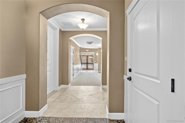 hallway featuring ornamental molding and light tile patterned flooring