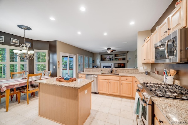 22428 Quail Run Ln, Parker, CO 80138 - kitchen featuring appliances with stainless steel finishes, light brown cabinetry, a sink, a kitchen island, and a peninsula