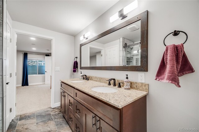 22428 Quail Run Ln, Parker, CO 80138 - bathroom featuring double vanity, tiled shower, baseboards, and stone finish floors