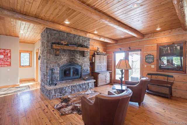 living room with plenty of natural light, a stone fireplace, wood-type flooring, and wooden ceiling