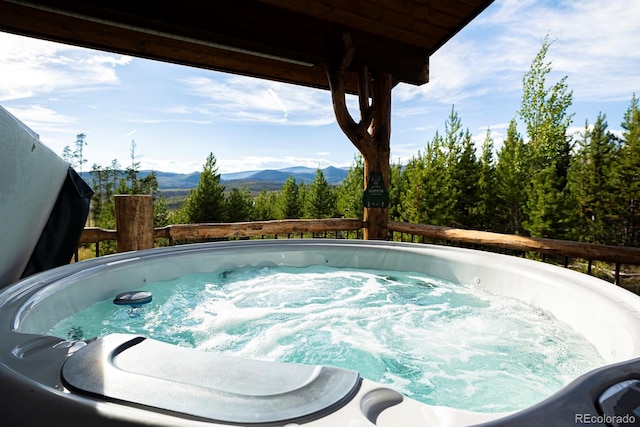 view of swimming pool with a mountain view and a hot tub