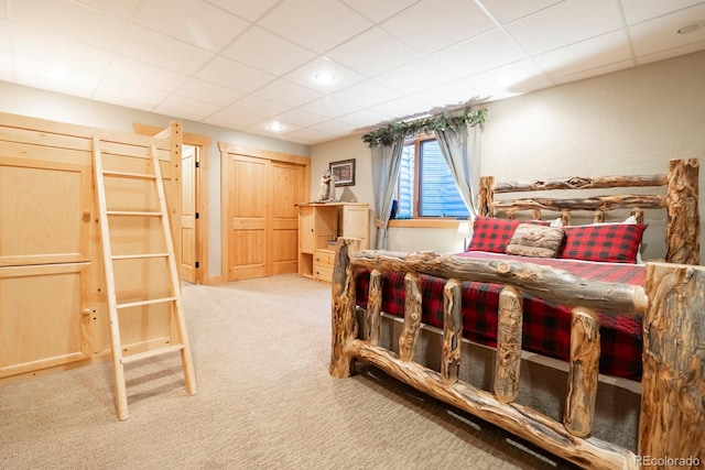 bedroom with carpet floors and a paneled ceiling