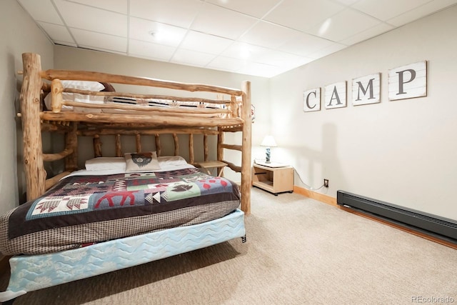 bedroom with a baseboard radiator, carpet, and a drop ceiling