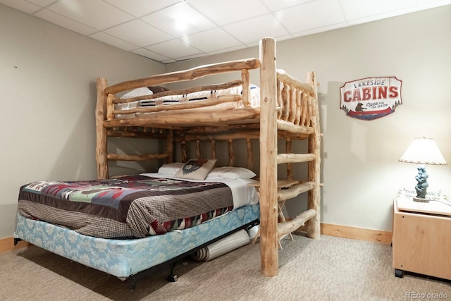 carpeted bedroom with a paneled ceiling