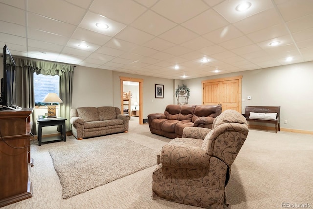 living room featuring a paneled ceiling and carpet