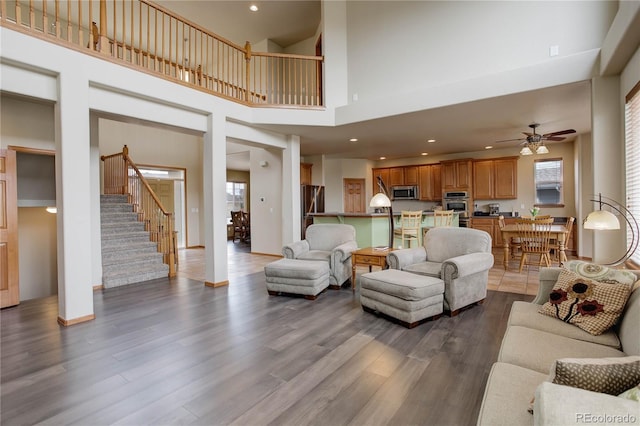 12754 Angelina Dr, Peyton, CO 80831 - living room with wood finished floors, stairway, ceiling fan, recessed lighting, and a towering ceiling
