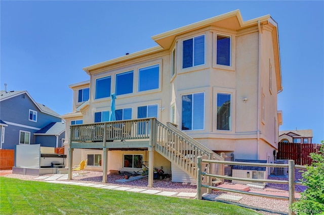12754 Angelina Dr, Peyton, CO 80831 - rear view of house featuring a hot tub, a wooden deck, stairway, and stucco siding