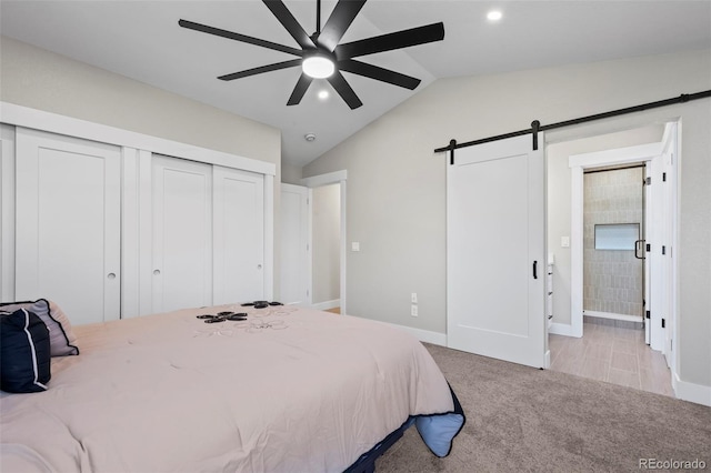 bedroom featuring a barn door, connected bathroom, light colored carpet, vaulted ceiling, and recessed lighting