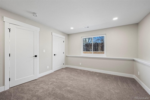 interior space featuring visible vents, baseboards, and carpet flooring