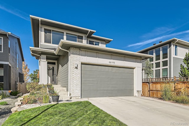 view of front facade with brick siding, concrete driveway, and fence