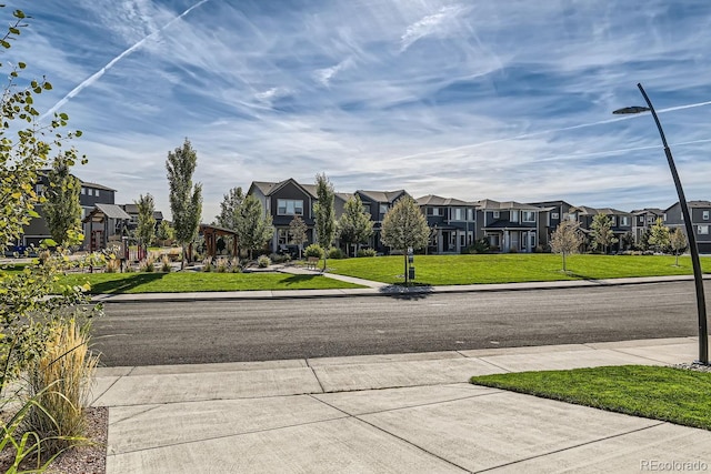 view of street featuring sidewalks, street lights, and a residential view