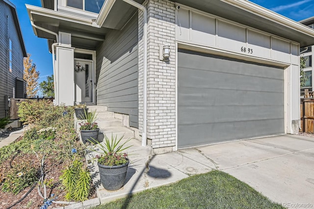 view of exterior entry with brick siding and driveway