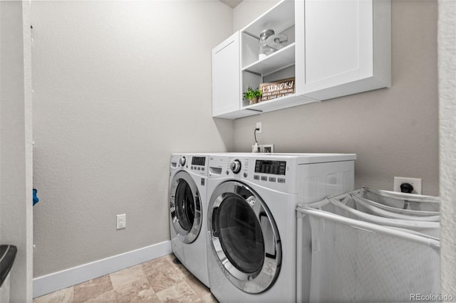 clothes washing area featuring cabinet space, baseboards, and separate washer and dryer