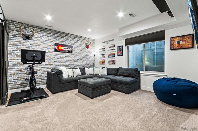 living room with brick wall, recessed lighting, visible vents, and carpet floors