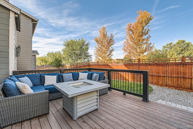 wooden terrace featuring an outdoor living space with a fire pit and a fenced backyard