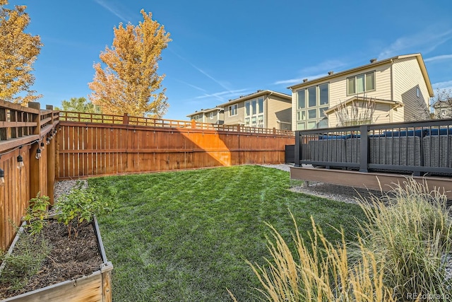 view of yard with a fenced backyard and a garden