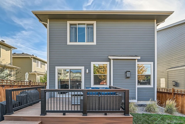 rear view of property with a wooden deck and fence