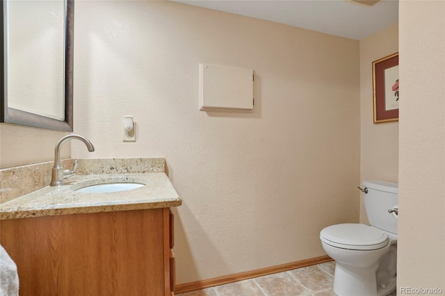 bathroom featuring tile patterned flooring, vanity, and toilet