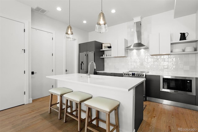 1250 W Osceola St Unit 2, Denver, CO 80204 - kitchen featuring open shelves, wall chimney range hood, stainless steel appliances, modern cabinets, and recessed lighting