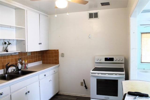 kitchen with tasteful backsplash, white cabinets, sink, and white electric stove