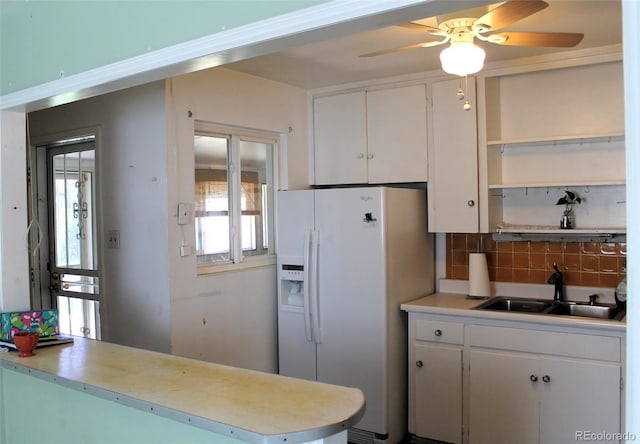 kitchen with ceiling fan, tasteful backsplash, white fridge with ice dispenser, sink, and white cabinetry