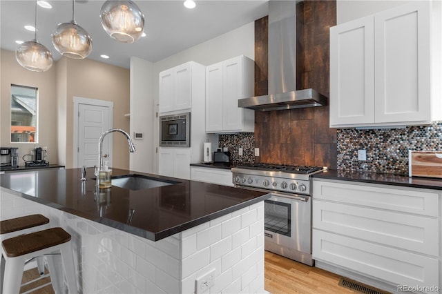 5046 Uinta St, Denver, CO 80238 - kitchen featuring wall chimney range hood, appliances with stainless steel finishes, dark countertops, tasteful backsplash, and recessed lighting