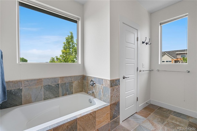 5046 Uinta St, Denver, CO 80238 - bathroom with a bath, healthy amount of natural light, and stone tile flooring