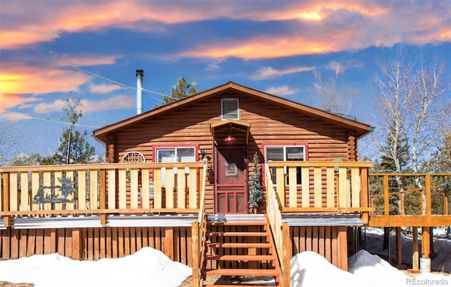 view of front of home with log exterior and a deck