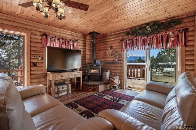 living area featuring log walls, ceiling fan, wood ceiling, a wood stove, and wood-type flooring
