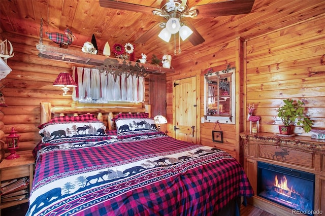 bedroom with log walls and a glass covered fireplace
