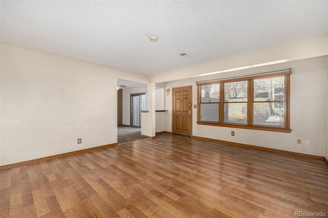 unfurnished living room featuring a textured ceiling and wood-type flooring