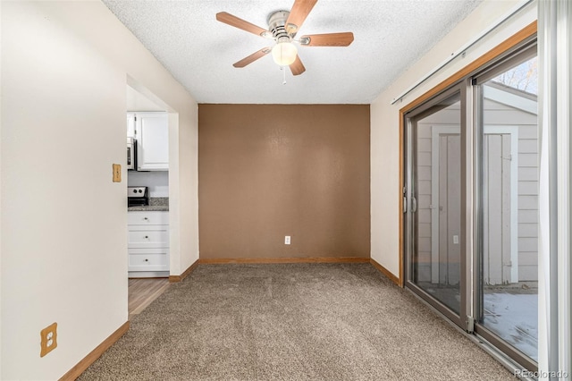 carpeted spare room with a textured ceiling and ceiling fan