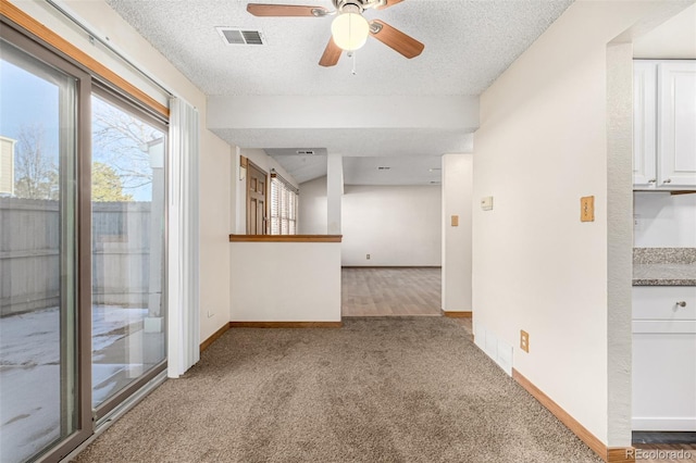 spare room featuring a textured ceiling, ceiling fan, and carpet floors