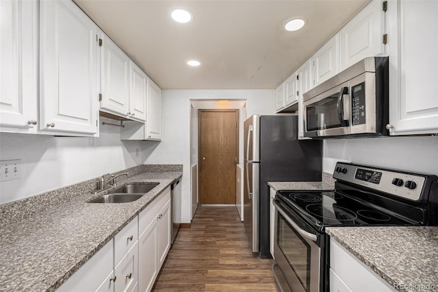 kitchen featuring hardwood / wood-style floors, white cabinets, appliances with stainless steel finishes, and sink