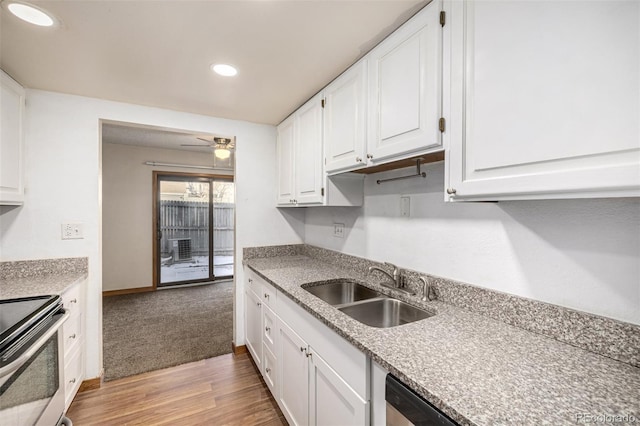 kitchen with light hardwood / wood-style floors, electric range, white cabinets, ceiling fan, and sink