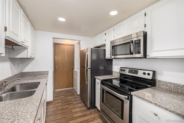 kitchen featuring appliances with stainless steel finishes, dark hardwood / wood-style flooring, white cabinets, and sink