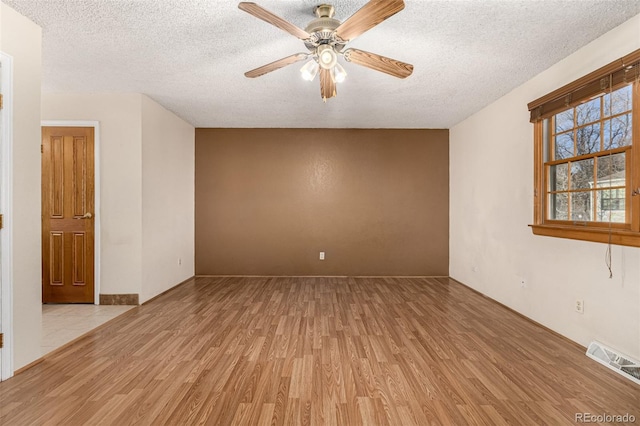 unfurnished room featuring a textured ceiling, ceiling fan, and light wood-type flooring