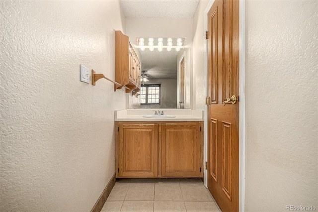 bathroom featuring a textured ceiling, tile patterned floors, and vanity