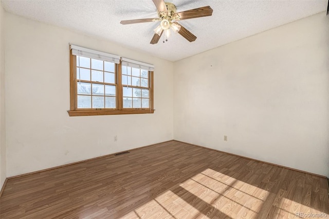 empty room featuring a textured ceiling, ceiling fan, and hardwood / wood-style flooring