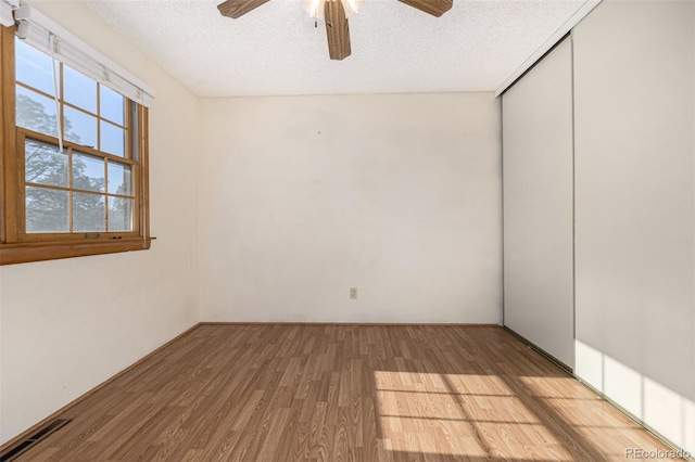 spare room featuring a textured ceiling, hardwood / wood-style floors, and ceiling fan