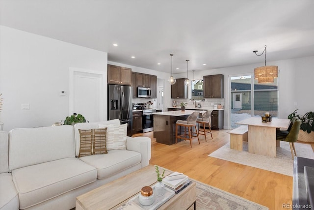 living room with light hardwood / wood-style flooring and sink