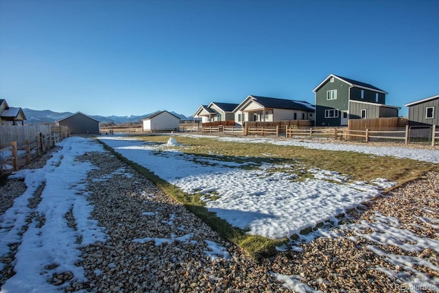 yard covered in snow with a mountain view